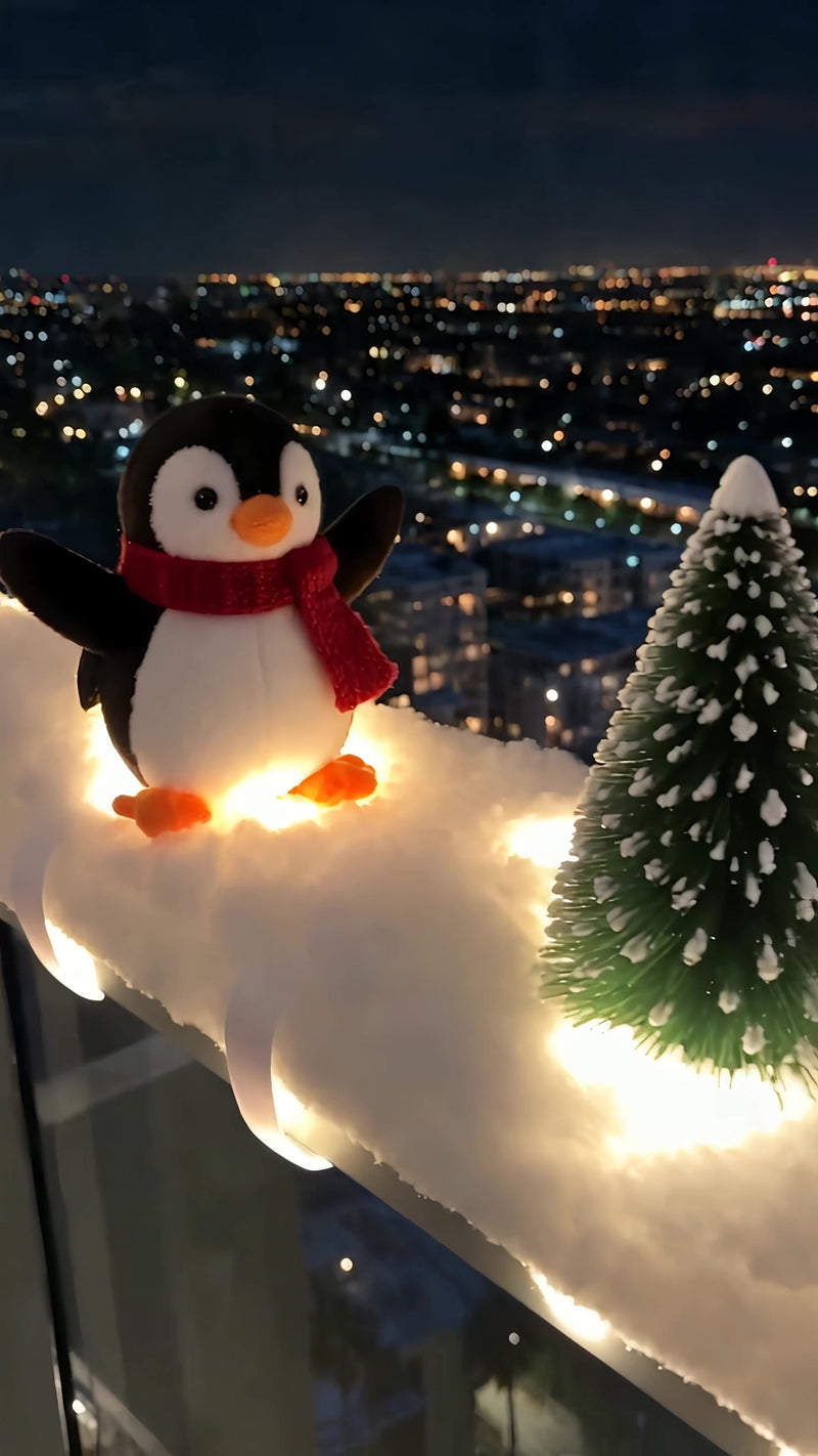 Plush penguin with red scarf on the lit snow garland